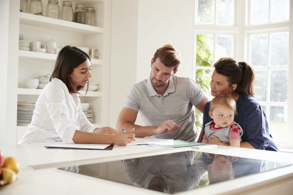 Family With Baby Meeting Financial Advisor At Home